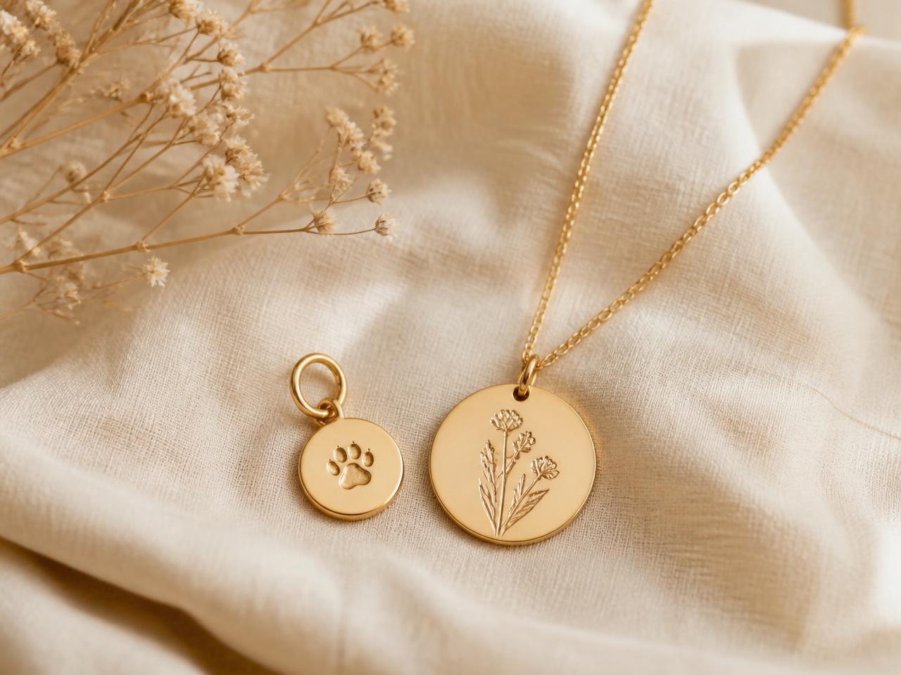 Matching gold jewellery for a pet and their owner, laid on cream linen